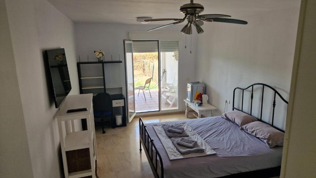 ein Schlafzimmer mit einem Bett und einem Deckenventilator in der Unterkunft HillView Rooms in Manilva in Manilva