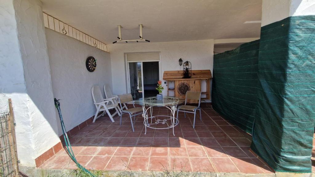 a patio with a table and chairs in a house at HillView Rooms in Manilva in Manilva