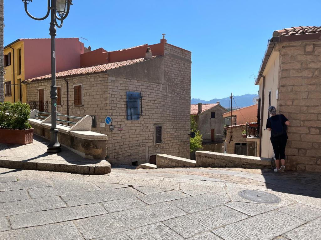a person walking down a street next to a building at La Musica del Vento in Aggius
