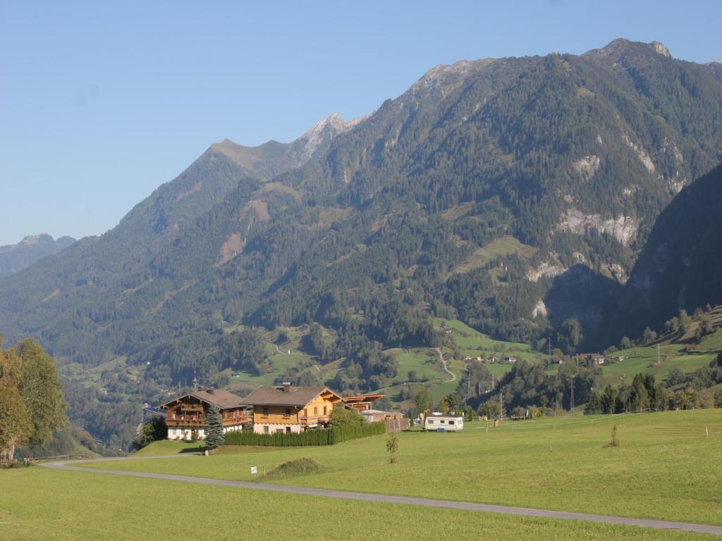a house in a field in front of a mountain at Apartment in Embach near Gastein Ski Area in Embach