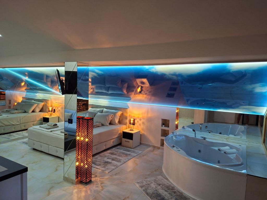 una habitación con bañera y una habitación con cama en Magic Spa Apartman, en Sremska Mitrovica