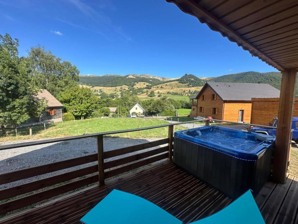 a hot tub on the deck of a house at Châlet au pied du Puy Mary in Le Claux