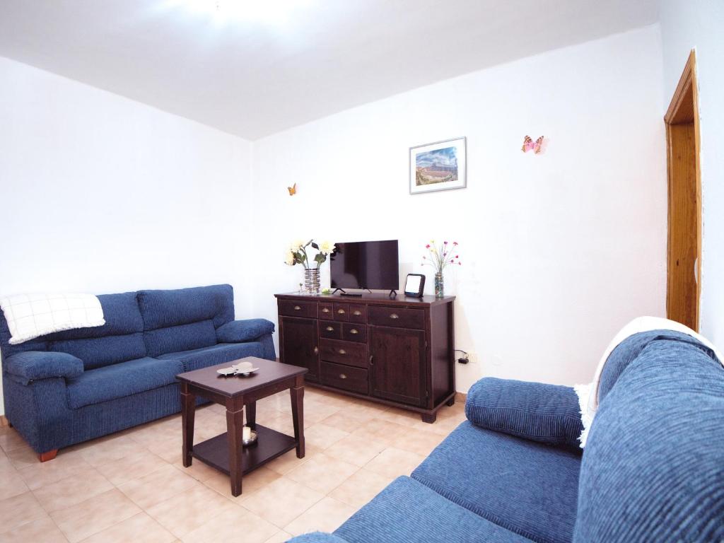 - un salon avec deux canapés bleus et une télévision dans l'établissement Piso capital La Mariposa, à Santa Cruz de Tenerife