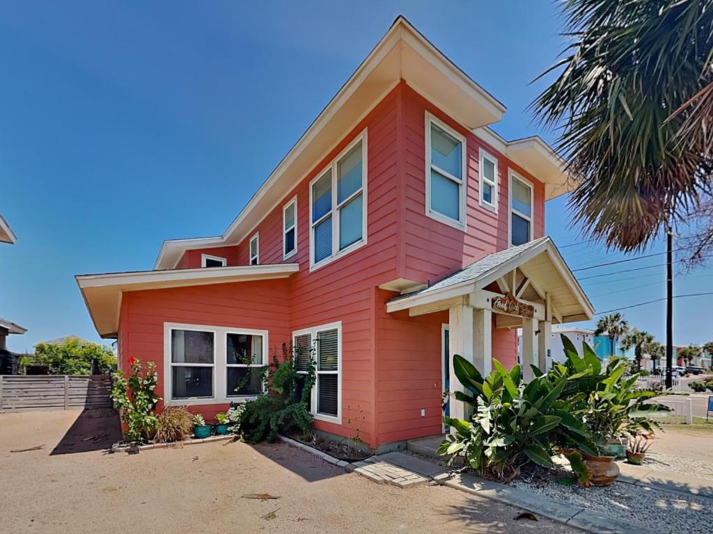 a red house with a palm tree in front of it at Royal Palm in Port Aransas