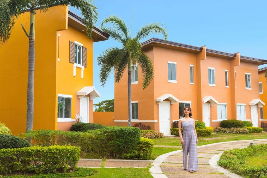a woman standing in front of a building at 2-Storey Town House 2 Bedroom in Conel