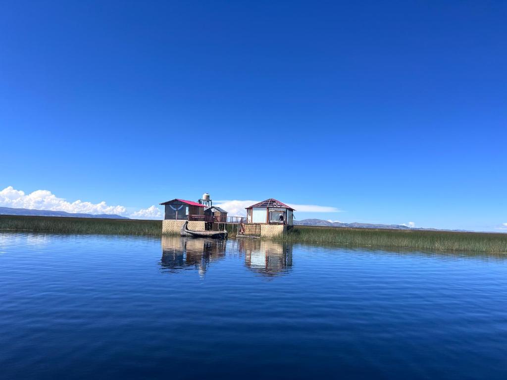 a house on a dock in the middle of a lake at QHOCHA Titikaka lodge in Puno