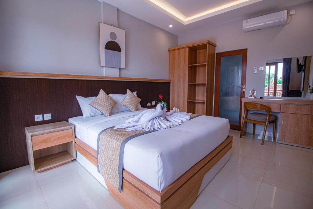 a bedroom with a large bed with white sheets at D'House Seminyak in Seminyak