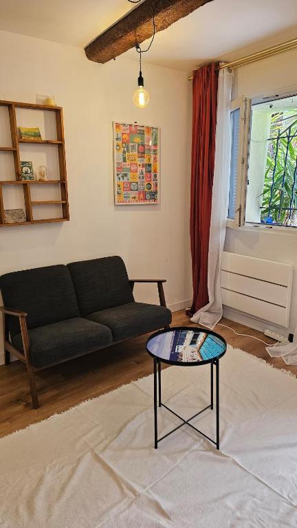 a living room with a couch and a table at Le panier à vos pieds in Marseille