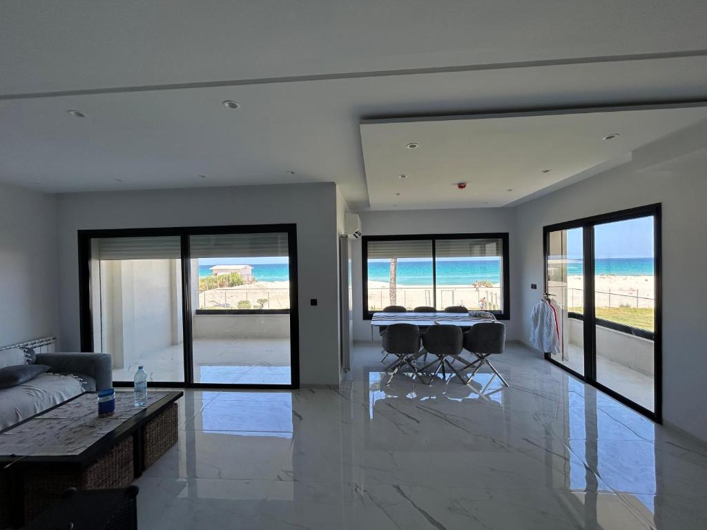 a living room with a table and chairs and the ocean at Luxury apartments in Hiboun
