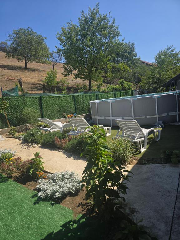 a garden with two chairs and a fence at Yellow hill Batinac in Ćuprija