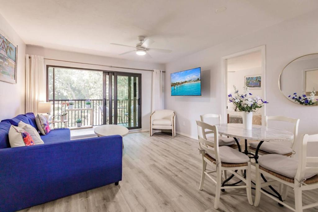 a living room with a blue couch and a table at Park Shore Resort Deluxe Condo, water views 232 in Naples