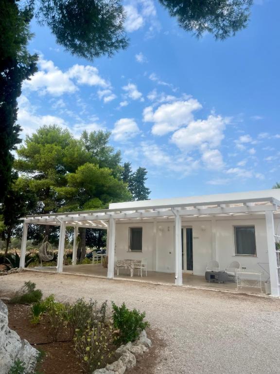 a white house with a pergola at Arneo Rooms in Torre Lapillo