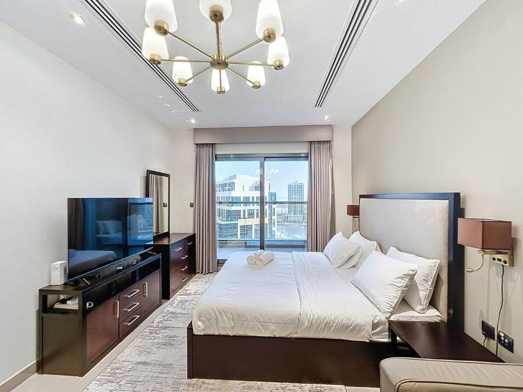 a bedroom with a bed and a flat screen tv at Stunning studio in Downtown Dubai in Dubai
