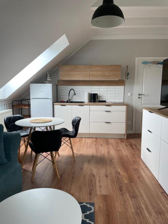 a kitchen and living room with a table and chairs at Dormare in Grzybowo