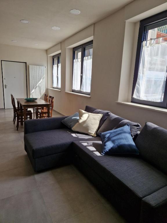 ein schwarzes Sofa im Wohnzimmer mit einem Tisch in der Unterkunft Concordia Apartment in Orta San Giulio