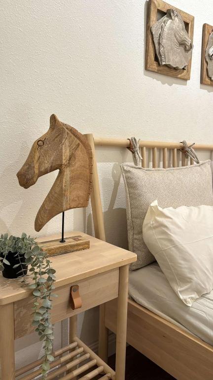 a wooden horse head on a table next to a bed at غرفة نوم مودرن بدخول ذاتي رقم سري in Tabuk