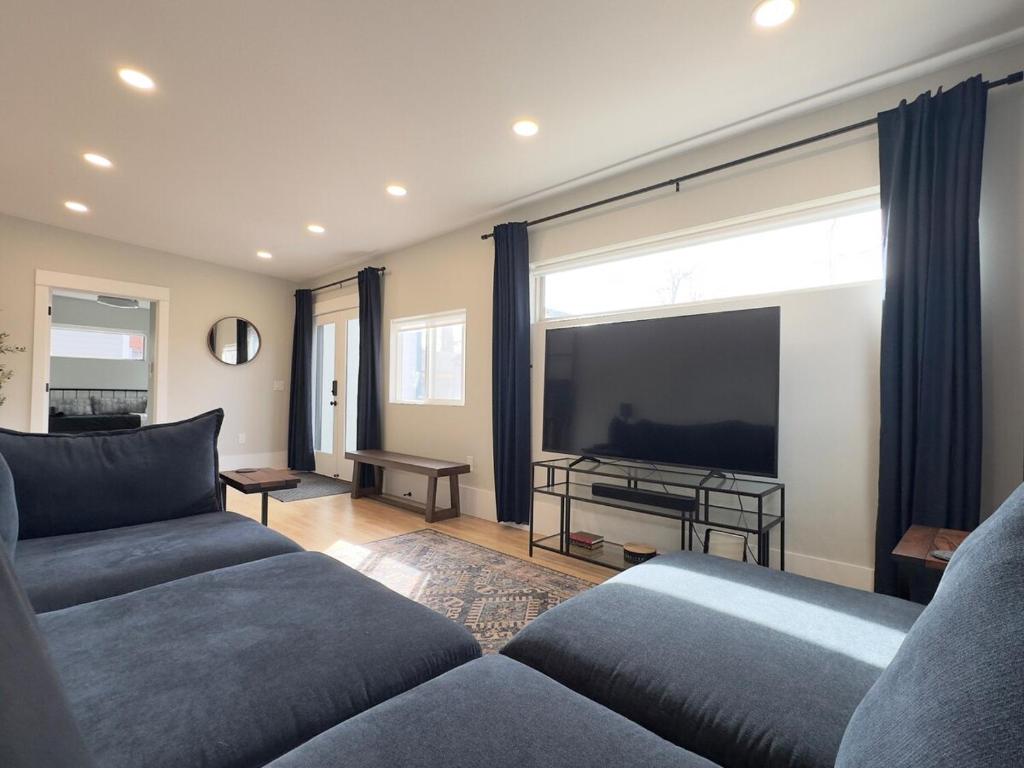 a living room with two couches and a large screen tv at NEW REMODEL Denver Luxury Home with Private HOT TUB in Denver