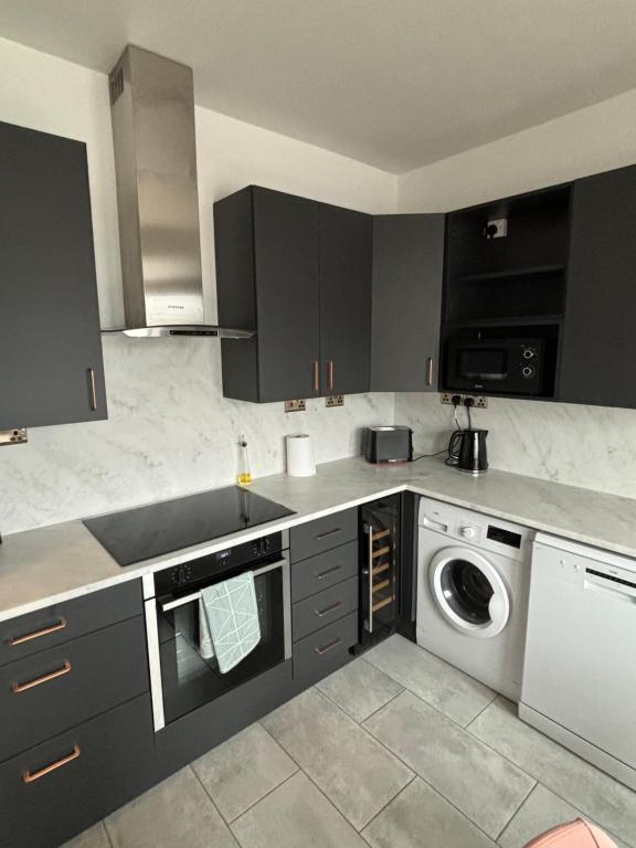 a kitchen with a sink and a washing machine at Basin Road 2 Bed House in Chichester