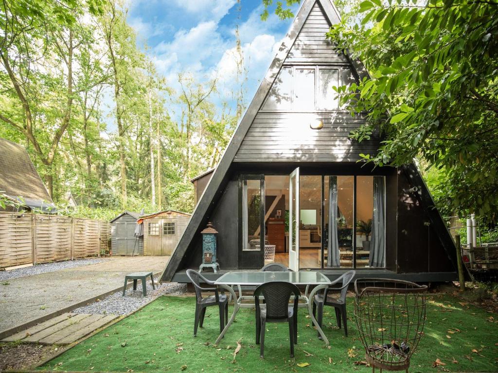 a small black house with a table and chairs at Lanaken Lakeside Cabin Stay in Lanaken