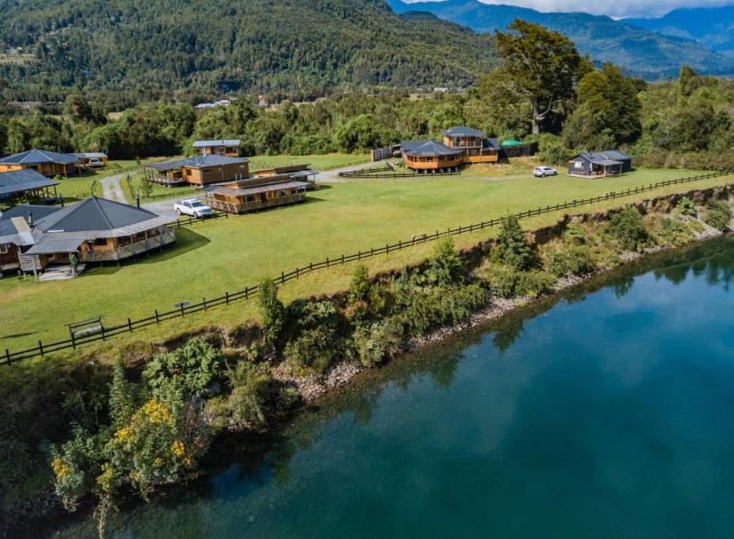 an aerial view of a house next to a river at Patagonia Puelo Lodge in Cochamó