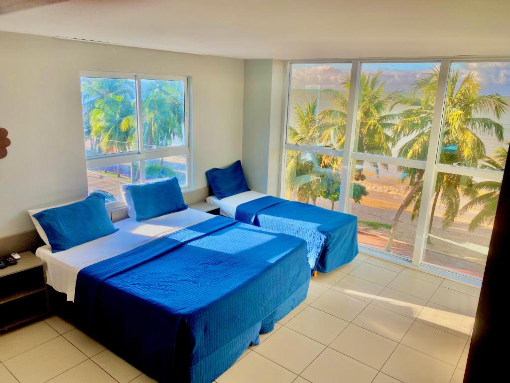 una camera da letto con due letti e una grande finestra di Melhor vista de João Pessoa 301 a João Pessoa