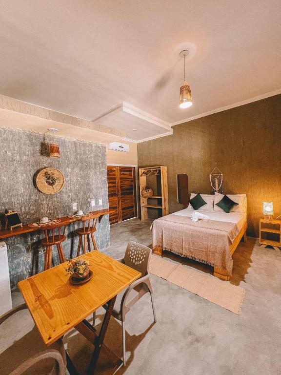 ein Hotelzimmer mit einem Bett und einem Tisch in der Unterkunft Ventania Aluguel por Temporada - Preá in Prea
