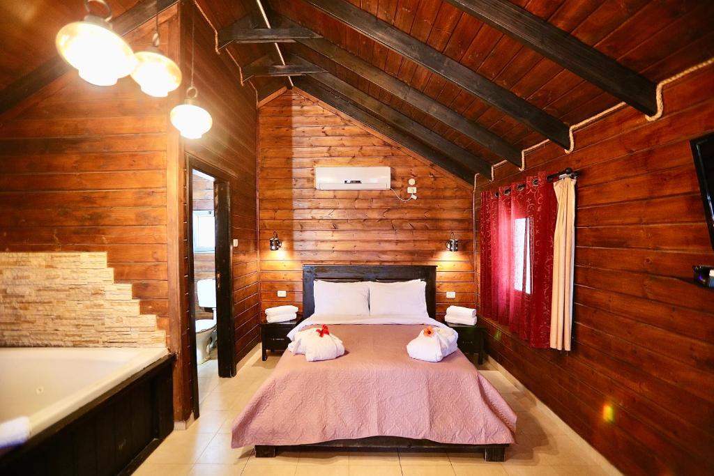 a bedroom with a bed and a bath tub at בקתות ההוד in Kallanit