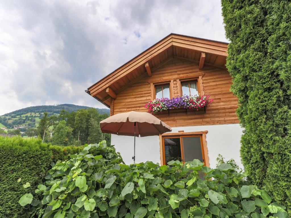 a small house with an umbrella in front of it at Cottage in Piesendorf near Zell am See Ski Area in Piesendorf