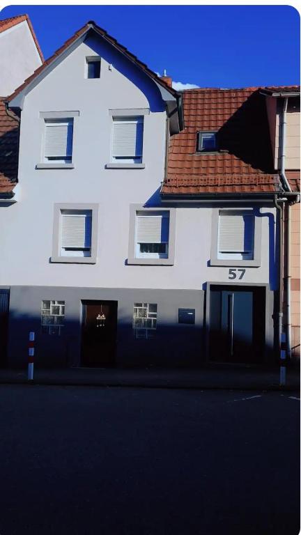 una casa blanca con techo marrón en Ferienzimmer in bad friedrichshall, en Bad Friedrichshall