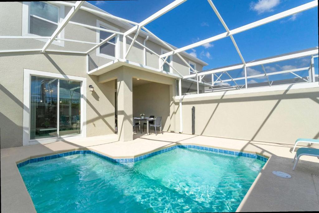 Hotel Gorgeous 4 Bd w/ Pool at Champions Gate Resort 1020, a swimming pool in front of a house at Gorgeous 4 Bd w/ Pool at Champions Gate Resort 1020 in Orlando