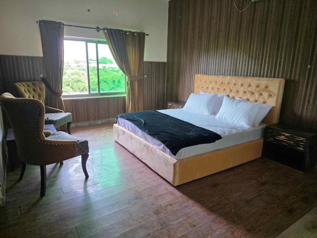 une chambre avec un lit, une chaise et une fenêtre dans l'établissement The Bedouin Home - F10, à Islamabad