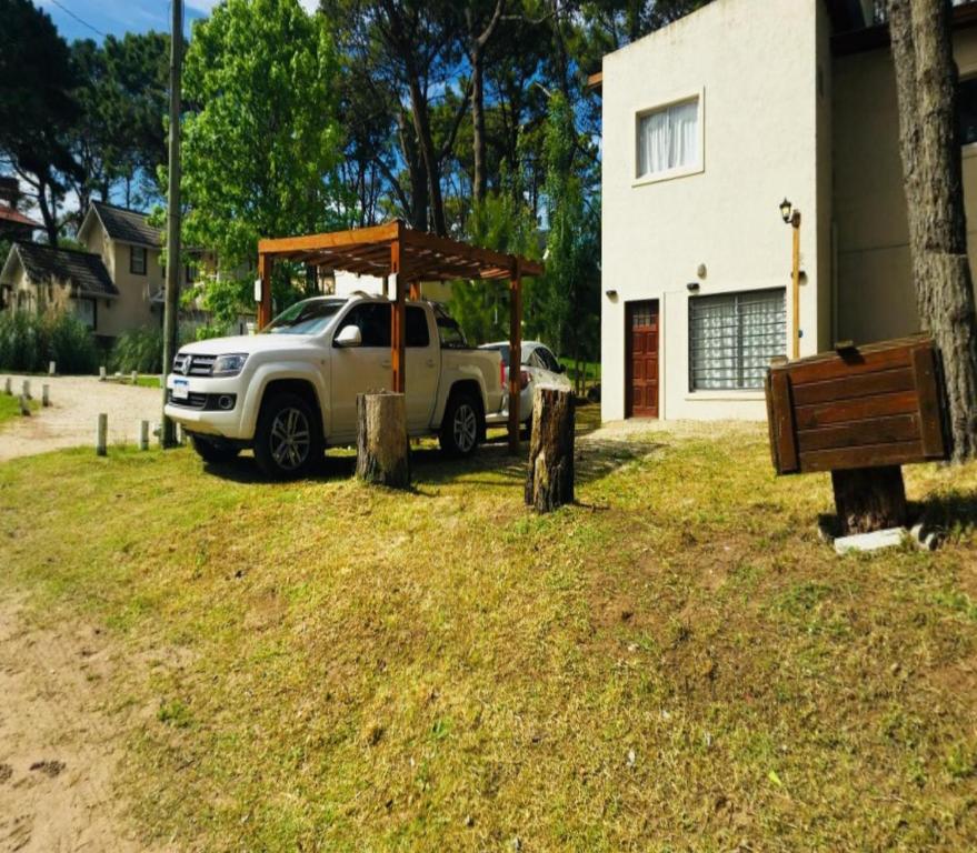Un camión blanco estacionado en un patio con techo de madera. en mi encanto, en Mar Azul