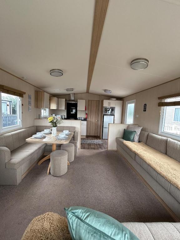 a living room with a couch and a table at Ty hedd static caravan in Caernarfon