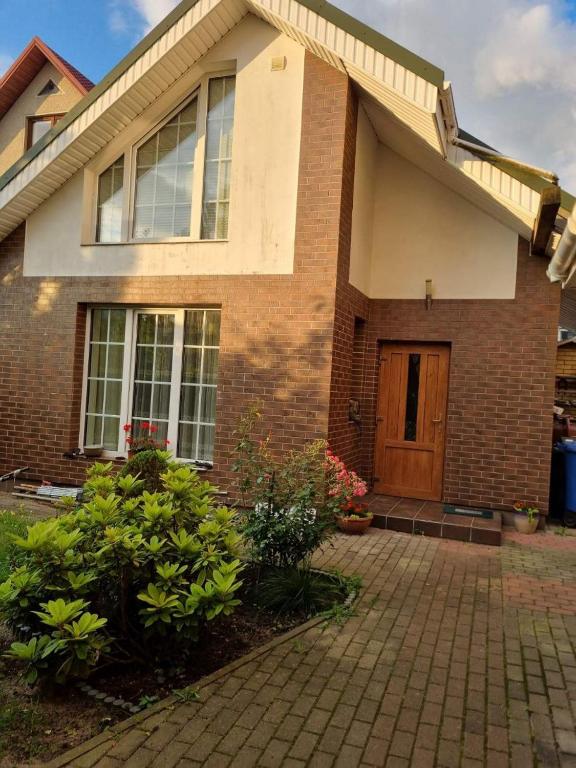a brick house with a door and a brick driveway at Apartamentai Giruliuose - privatus dviejų aukštų namas in Melnragė