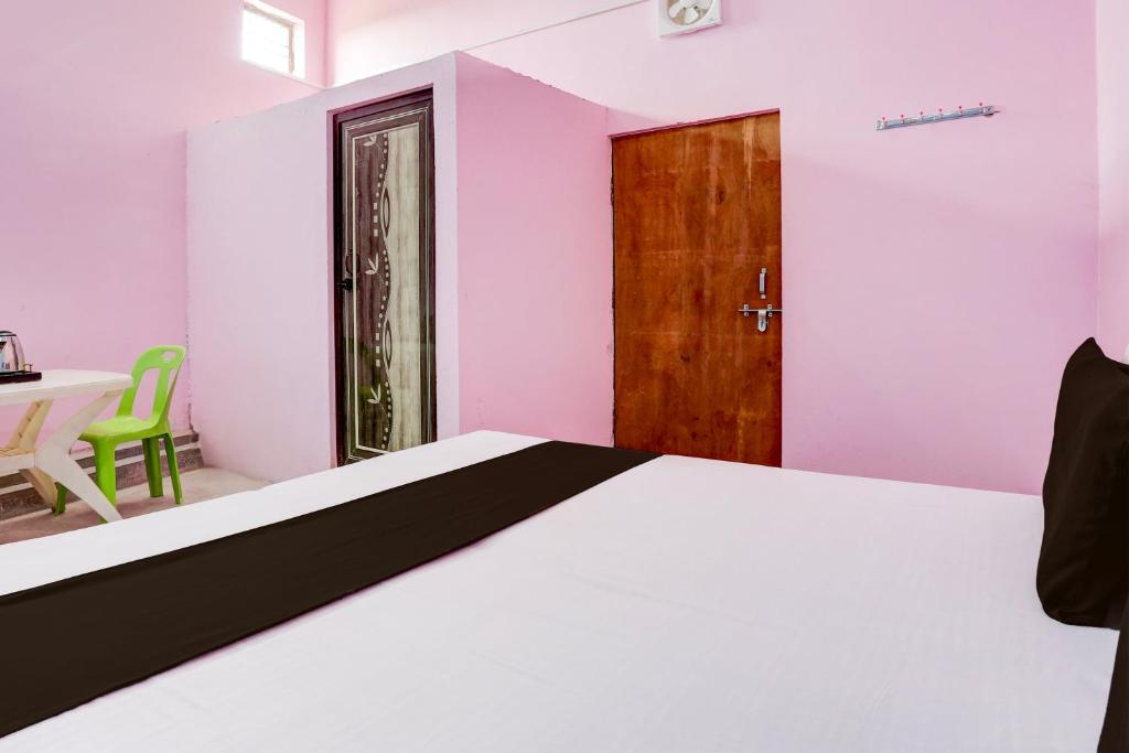 a bedroom with a bed and a table and a door at Hotel O BLUE DIAMOND HOTEL in Alīgarh