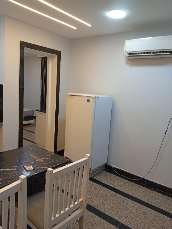 a room with a refrigerator and a table and chairs at ميراج باي اكوا بارك in Hurghada