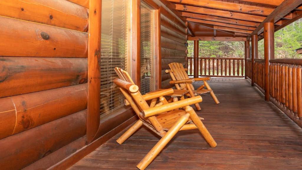 two chairs sitting on the porch of a cabin at Smoky Mountain Escape by American Patriot Getaways in Henderson Springs