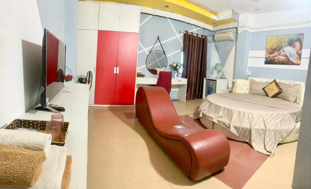 a living room with a bed and a leather chair at Gold Homes in Làng Chang