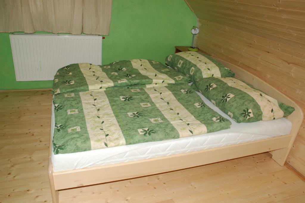 łóżko z zieloną kołdrą i poduszkami w obiekcie Agroturistika Malá Morávka w mieście Malá Morávka