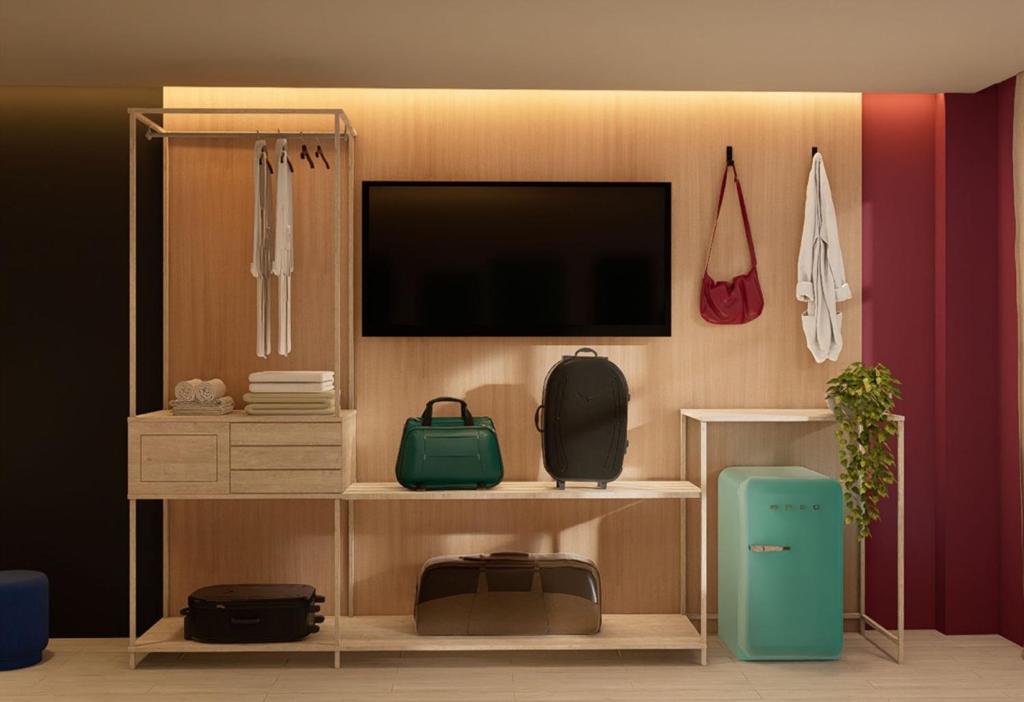 een woonkamer met een tv en een plank met tassen bij Hotel More By Kavia in Mexico-Stad
