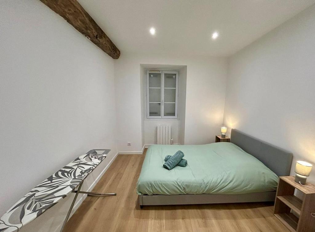 a white bedroom with a bed and a window at Quiet apartment - Touraine in Sorigny