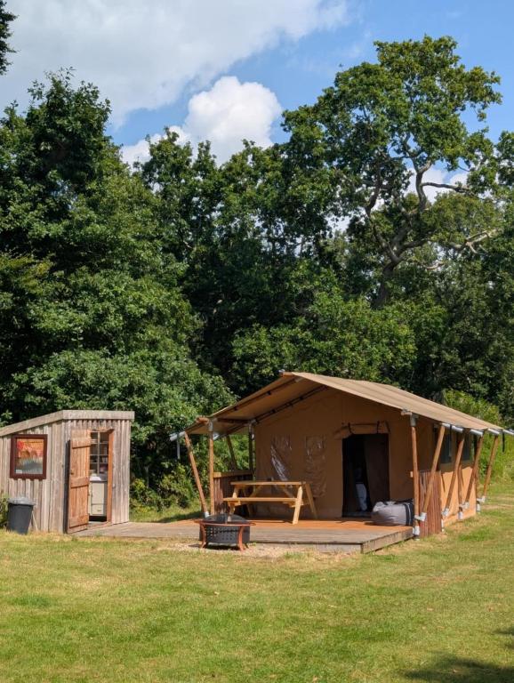 a large wooden hut in a grass field at Cefn Crib Safari Tent in Machynlleth