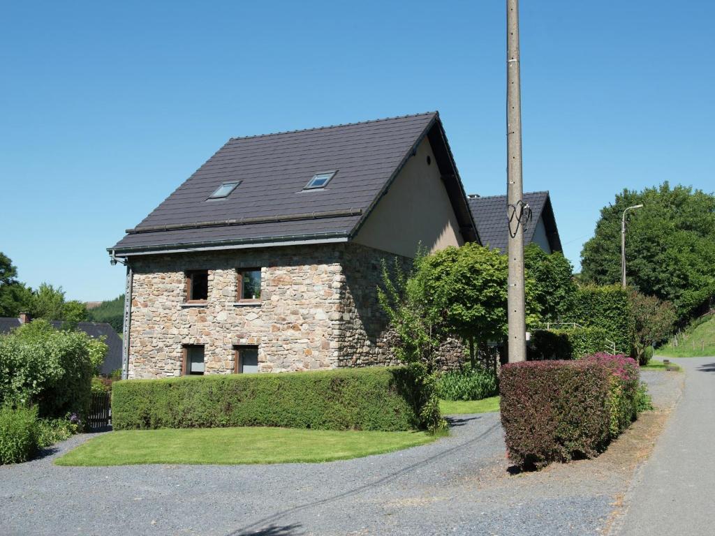a brick house with a black roof on a street at Les Terrasses Charming cottage in the heart of the Ardennes in Waimes
