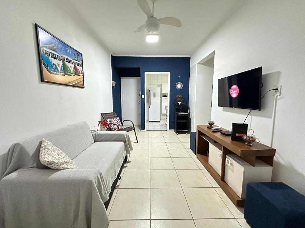 a living room with a couch and a tv at Apto 1 dorm no Canto do Forte - Próximo a Praia! in Praia Grande