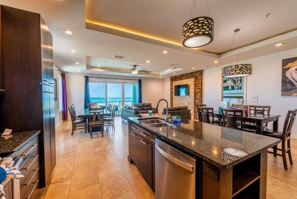 an open kitchen and dining room with a view of the ocean at 5 BEDROOM BEACHFRONT CONDO - 2nd Floor in South Padre Island