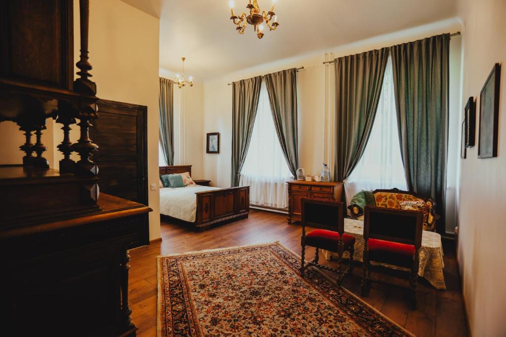 a bedroom with a bed and a table and chairs at Bērzgala Viesu Nams 