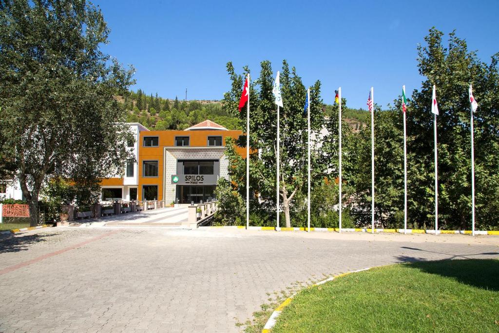 a row of flags on poles in front of a building at Spilos Hotel in Manisa