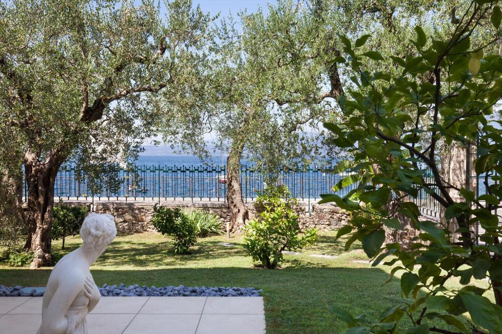 een standbeeld van een man die uitkijkt over het water bij Apartment Righini in Torri del Benaco