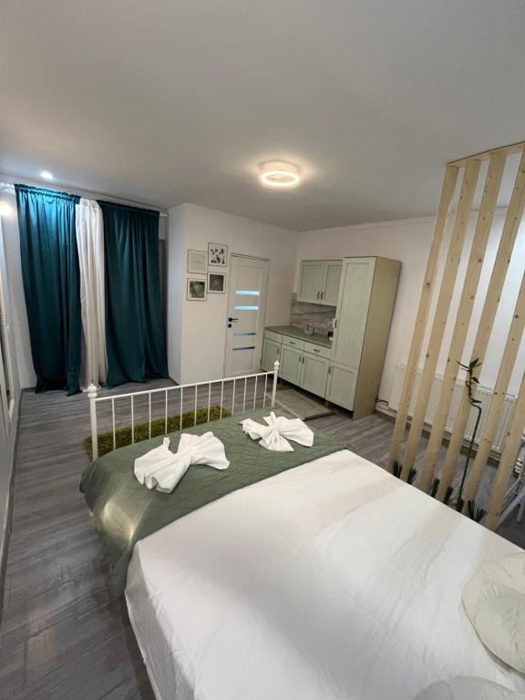 Un dormitorio con una cama grande con toallas. en Green House, en Onești