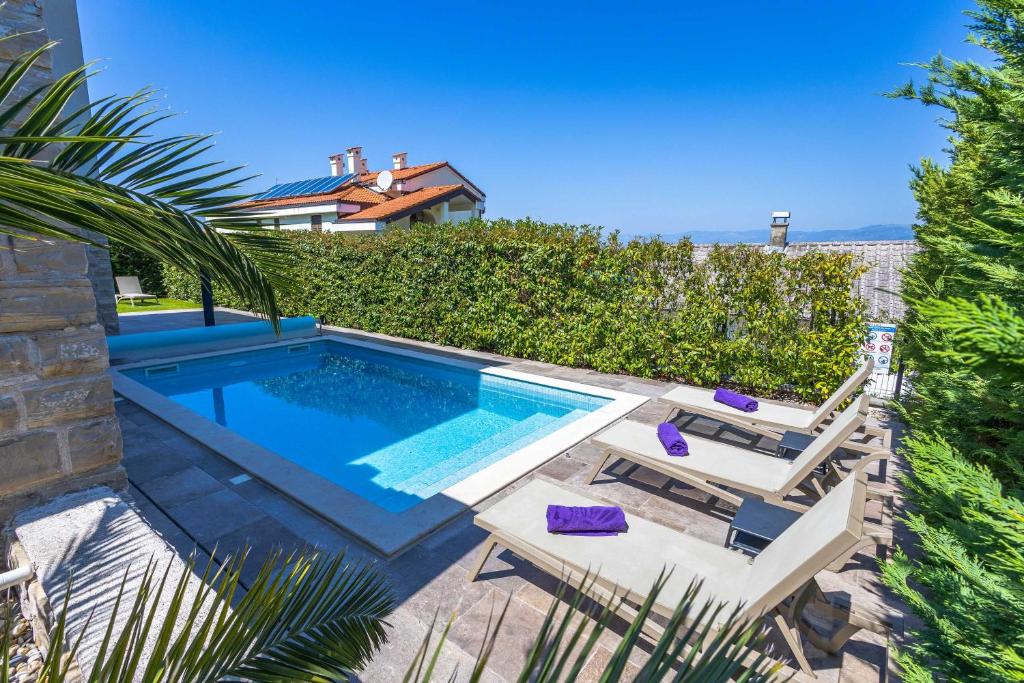una piscina en un patio con una villa en Apartment Siora, en Njivice